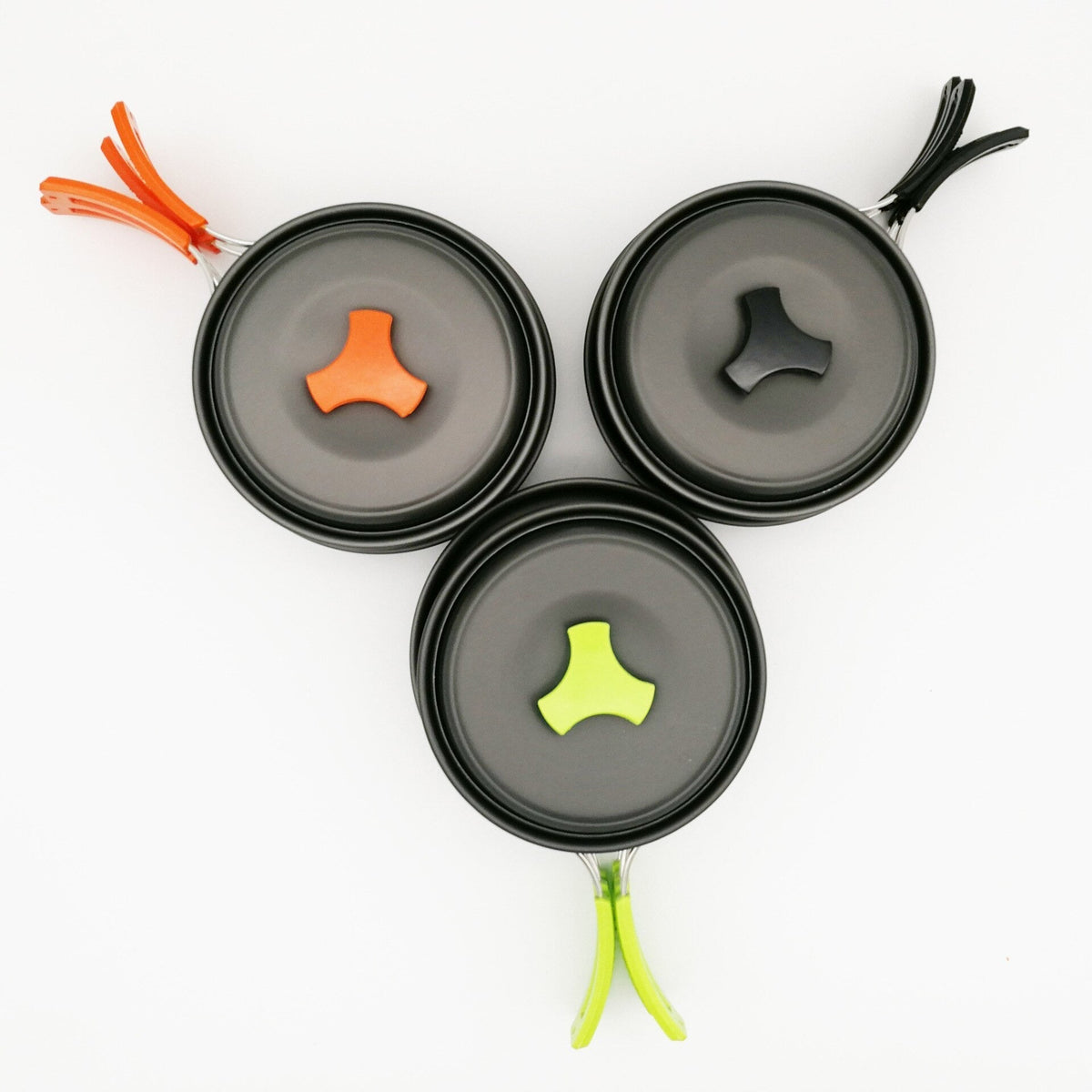 Drei Kochgeschirr-Sets von oben, Deckelknauf und Griffe in Orange, Grün und Schwarz