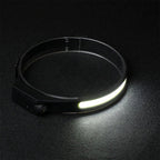 Stirnlampe auf dunklem Untergrund, das COB-Lichtband leuchtet breit
