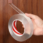 Rolle transparentes doppelseitiges Klebeband in der Hand vor einer Holzwand