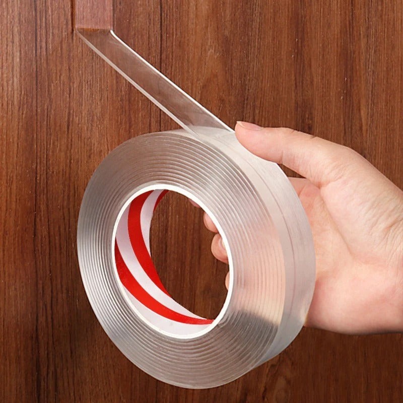 Rolle transparentes doppelseitiges Klebeband in der Hand vor einer Holzwand