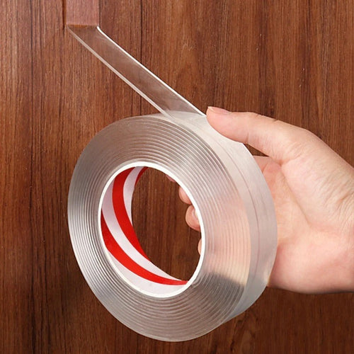 Rolle transparentes doppelseitiges Klebeband in der Hand vor einer Holzwand